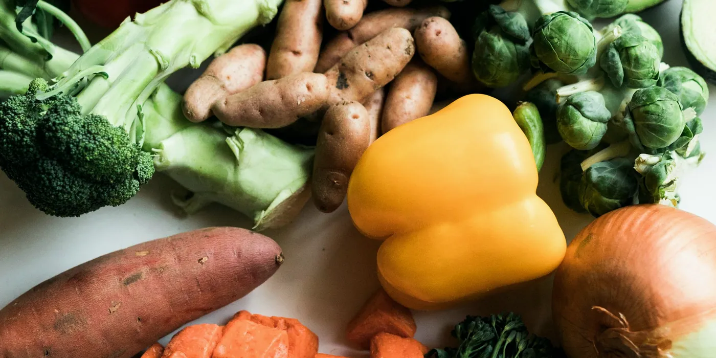 Assortiment de légumes frais : brocolis, patates douces, poivron jaune, oignon