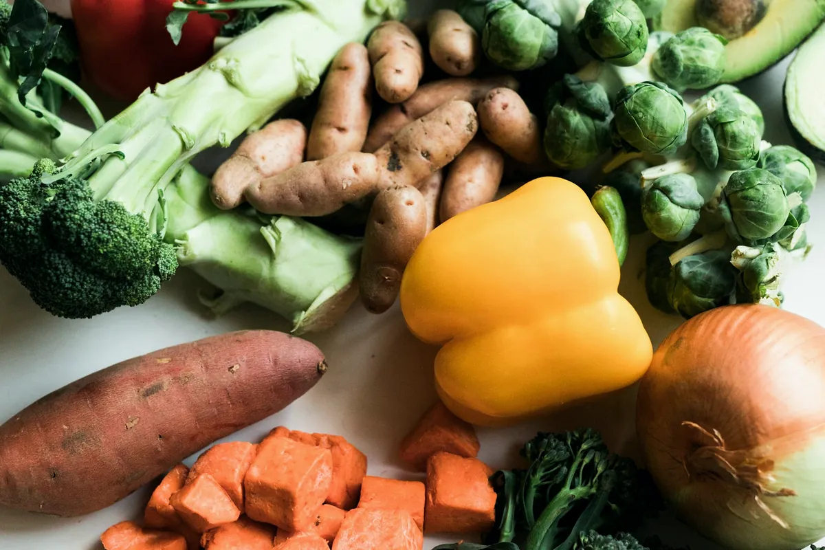 Assortiment de légumes frais : brocolis, patates douces, poivron jaune, oignon
